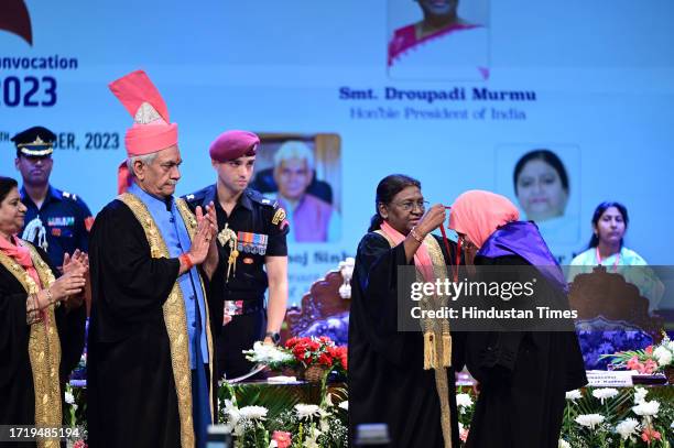 President Droupadi Murmu presents a gold medal to a student as Jammu and Kashmir Lieutenant Governor Manoj Sinha looks on at the 20th convocation of...