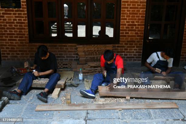 In this photograph taken on June 14 artisans chisel wood at the Nepal Vocational Academy in Bhaktapur on the outskirts of Kathmandu. Nepal's deadly...