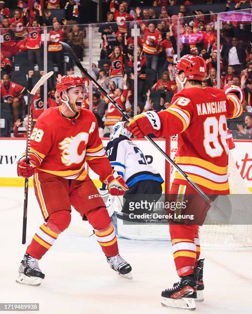 Elias Lindholm of the Calgary Flames celebrates after scoring on Connor Hellebuyck of the Winnipeg Jets during the third period of an NHL game at...