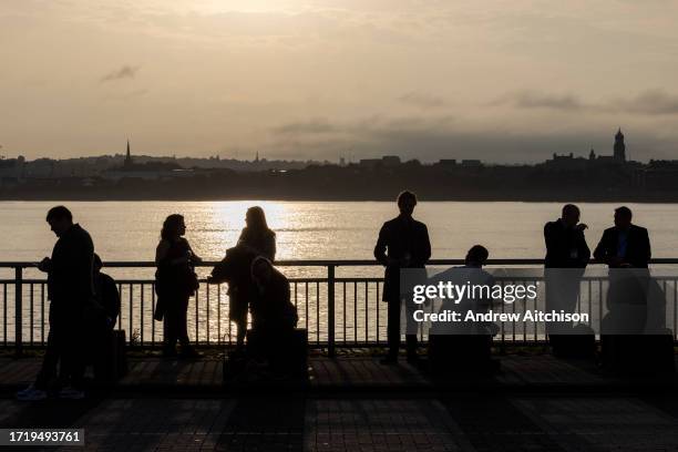 Delegates relaxing by the river Mersey as the sun sets outside the ACC Liverpool conference hall on second day of the Labour Party conference, Monday...
