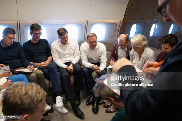 Christian Lindner , Federal Minister of Finance, speaks into an airplane during a background interview with journalists. Lindner is traveling to...