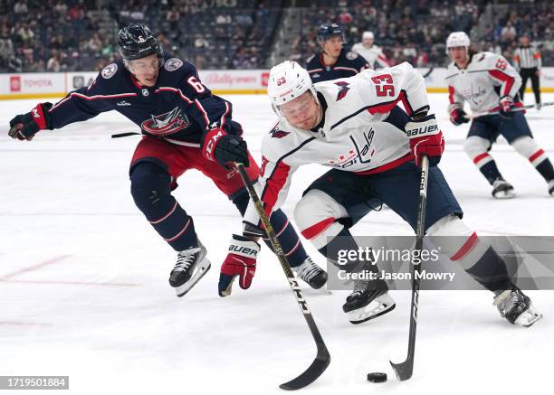 Ethen Frank of the Washington Capitals skates with the puck while Billy Sweezey of the Columbus Blue Jackets defends during the first period of a...