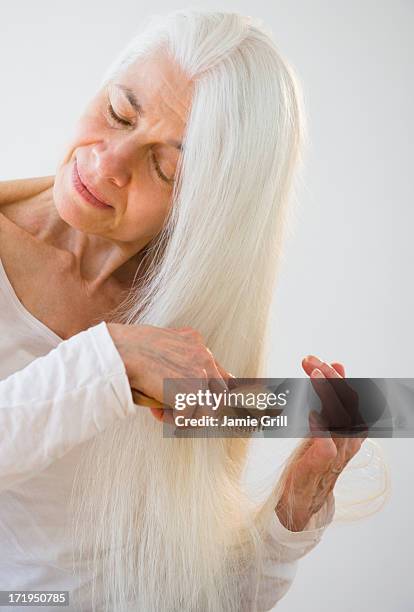 senior woman brushing hair - brushing hair stock pictures, royalty-free photos & images