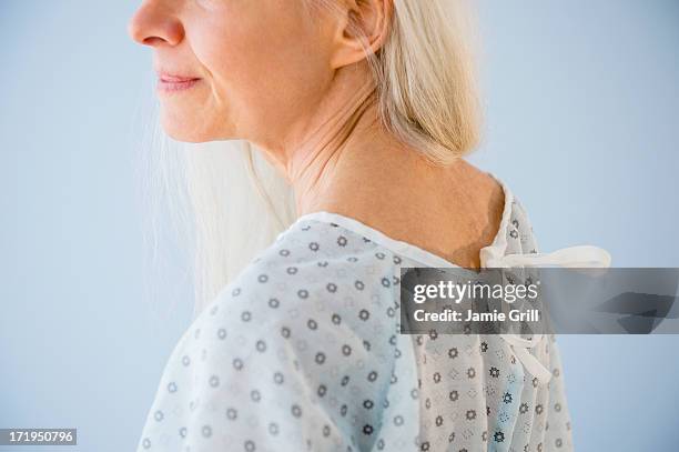 senior woman in hospital gown - hospital gown stock-fotos und bilder