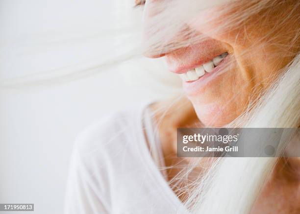 wind blown senior woman, smiling - canas fotografías e imágenes de stock