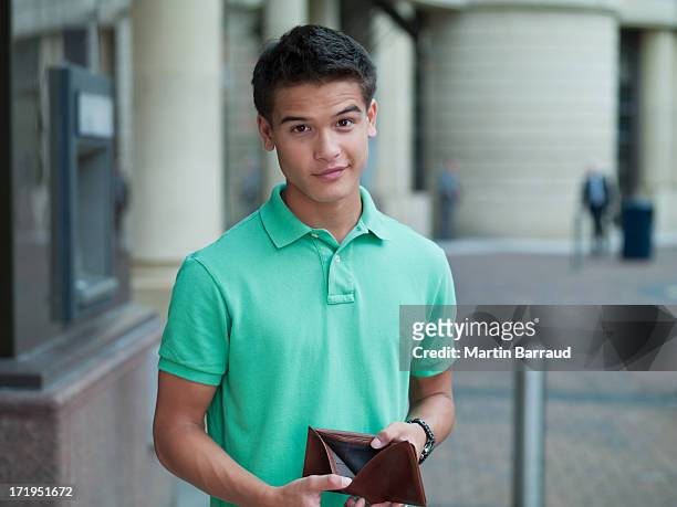 unzufriedener mann hält leere brieftasche in atm-maschine - empty wallet stock-fotos und bilder