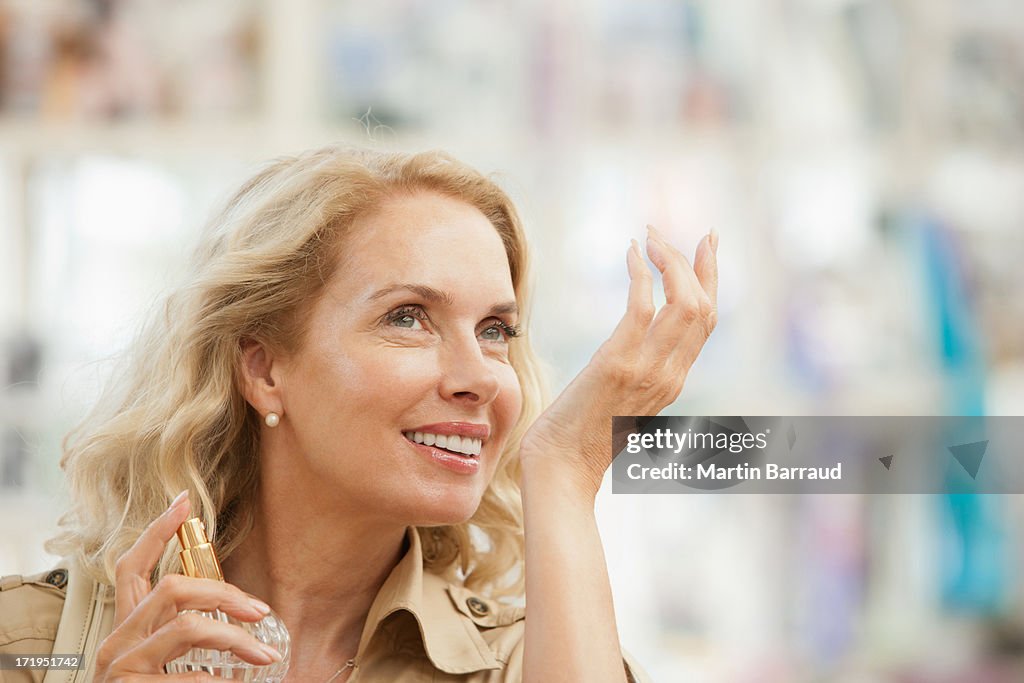 Femme souriante de tests parfum du magasin