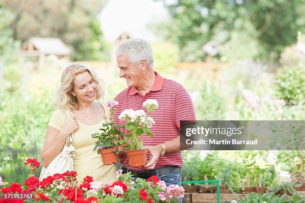 couple shopping for flowers in nursery - buying flowers stock pictures, royalty-free photos & images