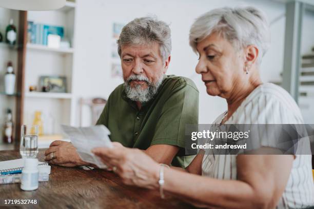 senior couple medicating at home with medical prescription - antioxidant support stock pictures, royalty-free photos & images