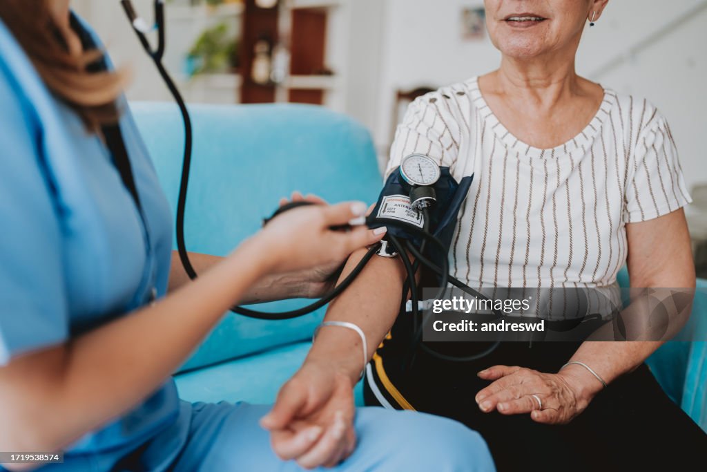 Home care healthcare professional measuring blood pressure