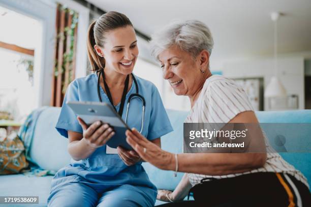 home care healthcare professional using digital tablet - healthcare professional stock pictures, royalty-free photos & images
