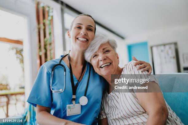 home care healthcare professional hugging senior patient - female nurse stock pictures, royalty-free photos & images