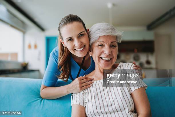 operatore sanitario domiciliare che abbraccia il paziente anziano - caregiver and senior foto e immagini stock