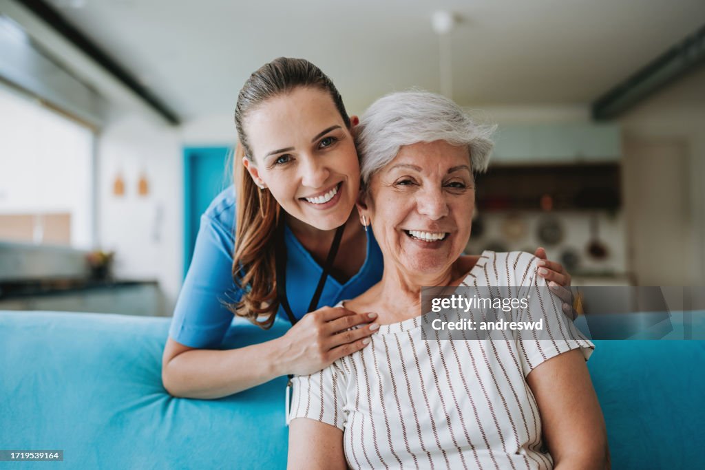 Home care healthcare professional hugging senior patient