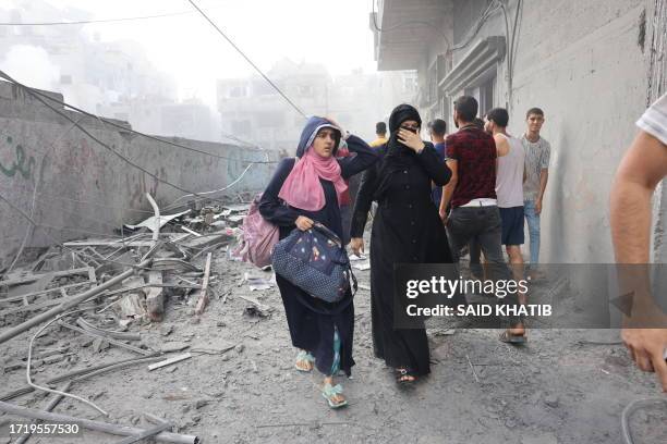 Graphic content / Women flee following an Israeli strike, as battles between Israel and the Hamas movement continue for the sixth consecutive day, in...