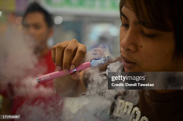 Consumers smoke electronic cigarettes at a mall on June 30, 2013 in Manila, Philippines. Electronic cigarettes are gaining popularity among former...