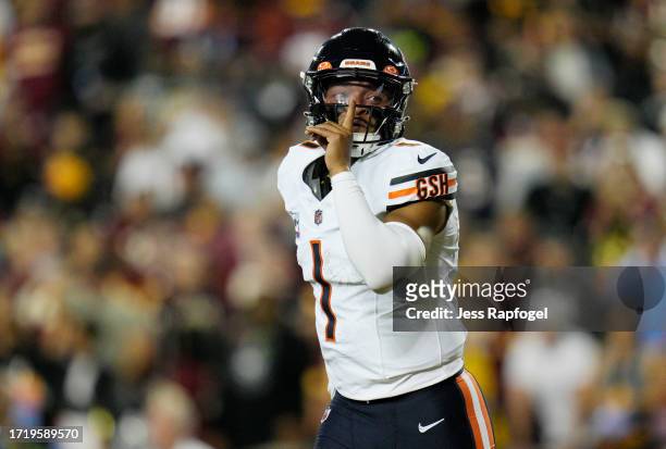 Justin Fields of the Chicago Bears gestures after scoring a touchdown during the first quarter against the Washington Commanders at FedExField on...