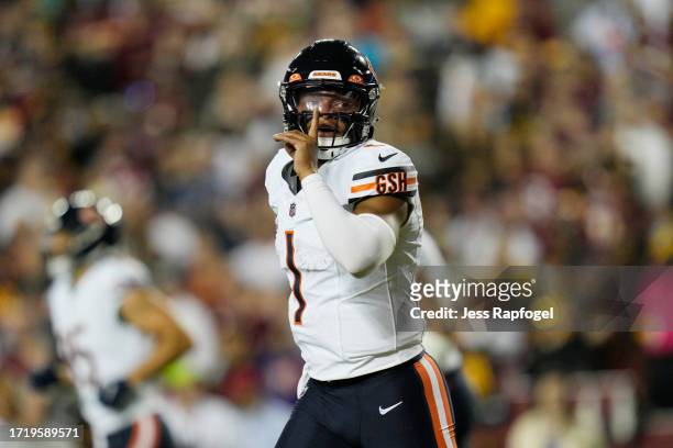 Justin Fields of the Chicago Bears gestures after scoring a touchdown during the first quarter against the Washington Commanders at FedExField on...
