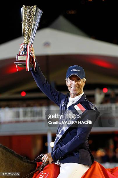 Rider Richard Spooner winner of the horse jumping competition holds his trophy at the end of the 2013 Monaco International Jumping as part of Global...