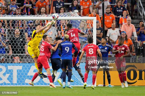 Alec Kann of FC Cincinnati goes up against Andrés Reyes of New York Red Bulls during the second half of an MLS soccer match at TQL Stadium on October...