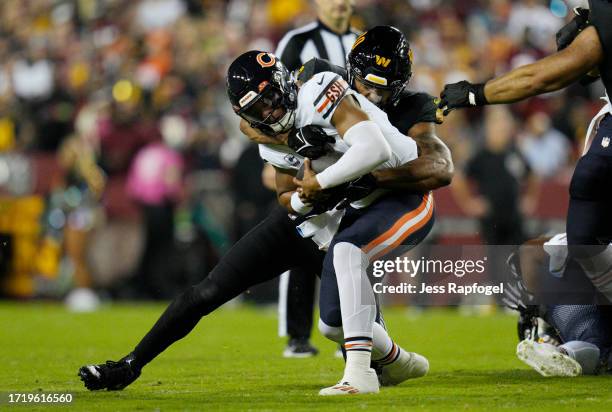 Justin Fields of the Chicago Bears is sacked by Montez Sweat of the Washington Commanders during the first quarter at FedExField on October 05, 2023...