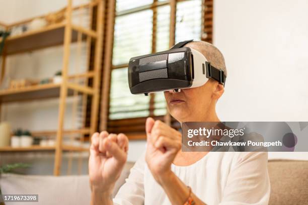 happy senior woman using vr headset to play online video game and connect to social media - real time stock pictures, royalty-free photos & images