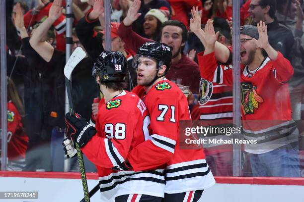 Taylor Hall of the Chicago Blackhawks celebrates with Connor Bedard after scoring a goal against the Minnesota Wild during the second period of a...