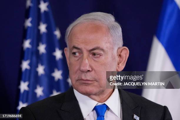 Israeli Prime Minister Benjamin Netanyahu looks on as the US Secretary of State gives statements to the media inside The Kirya, which houses the...