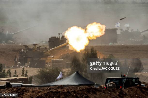 An Israeli army M109 155mm self-propelled howitzer fires rounds near the border with Gaza in southern Israel on October 12, 2023. Thousands of...