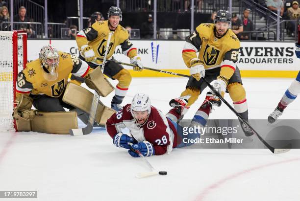Miles Wood of the Colorado Avalanche tries to get a rebound against Shea Theodore of the Vegas Golden Knights after a save by Logan Thompson of the...