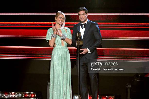 Paris Hilton and Danilo Carrera speak onstage during the 2023 Billboard Latin Music Awards at Watsco Center on October 05, 2023 in Coral Gables,...