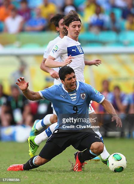Luis Suarez of Uruguay tangles with Riccardo Montolivo of Italy during the FIFA Confederations Cup Brazil 2013 3rd Place match between Uruguay and...