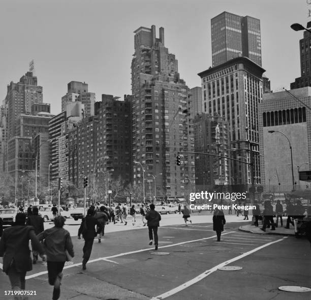 Pedestrians and traffic on the streets with Columbus Circle in the background, Midtown Manhattan, New York City, New York, April 1975. The traffic...