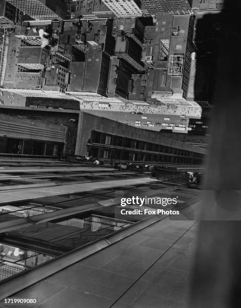 View of window cleaners in cradles and the streets below from an upper window of the 102-storey Empire State Building, in Midtown Manhattan, New York...