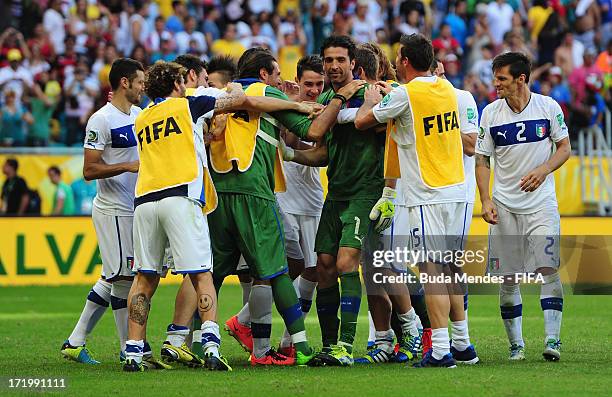 Gianluigi Buffon of Italy celebrates with his team-mates after saving the penalty of Walter Gargano of Uruguay to clinch victory in a shootout during...