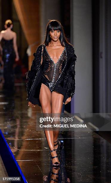 British model Naomi Campbell presents creations by Italian designer Donatella Versace during the Haute Couture Autumn/Winter 2013-2014 Versace...