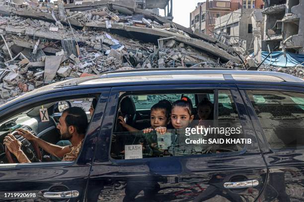 Graphic content / Palestinians drive amid the rubble of buildings destroyed in an Israeli air strike in Rafah, on the southern Gaza Strip on October...