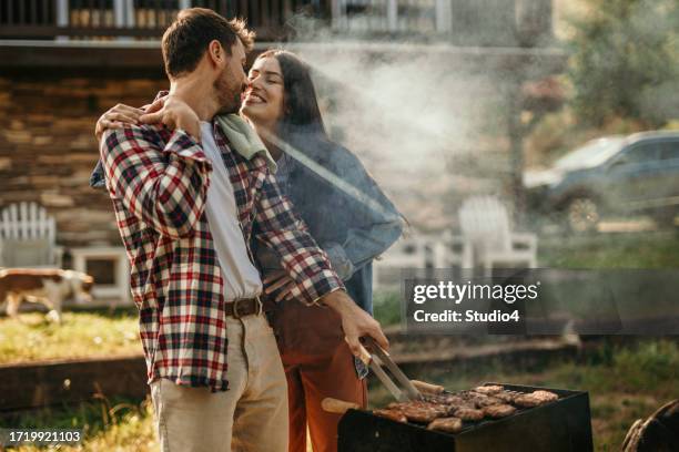 grillglück im garten - couple grilling stock-fotos und bilder