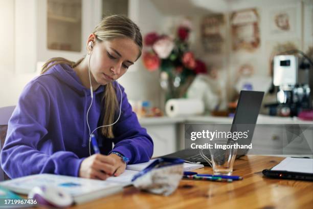 teenager-mädchen, das laptop benutzt, um hausaufgaben zu hause zu machen - daily life in poland stock-fotos und bilder