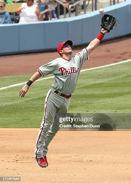 Third baseman Michael Young of the Philadelphia Phillies jumps to catch a high bouncer before throwing out Jerry Haiston Jr. Of the Los Angeles...