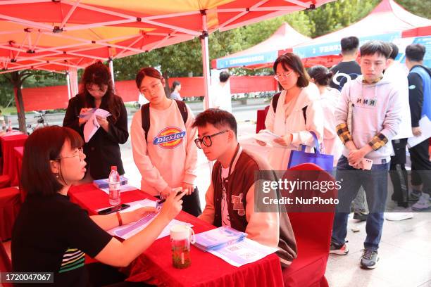 College students look for suitable positions at a recruitment site in Lianyungang, Jiangsu Province, China, Oct 12, 2023.