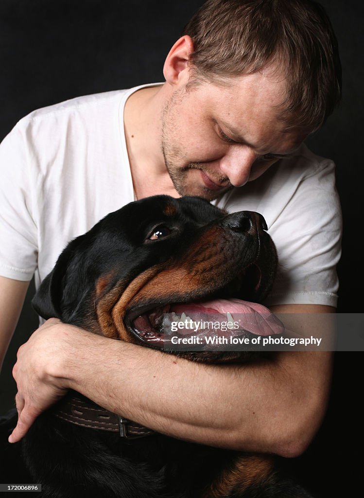 Huge black rottweiler dog and his owner