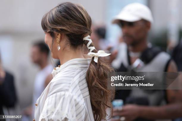 Guest is seen outside Zimmermann show wearing white and grey striped lace top during the Womenswear Spring/Summer 2024 as part of Paris Fashion Week...