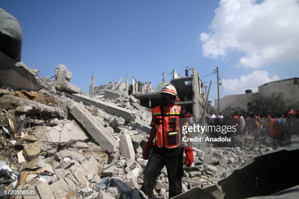 Civil defense teams conduct an search and rescue operation in rubbles of destroyed buildings as Israeli airstrikes continue on the sixth day in...