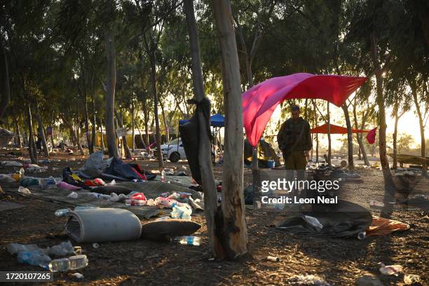 Israeli soldiers continue to search for ID and belongings among the cars and tents at the Supernova Music Festival site on October 12, 2023 in...