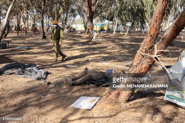 Graphic content / An Israeli soldier walks past the body of a Palestinian gunman during a search at the site of the weekend attack by Palestinian...