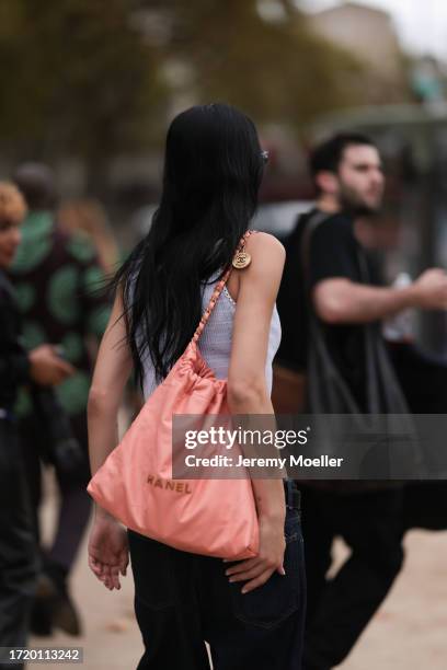 Amelia Gray is seen outside Chanel show wearing black Chanel sunnies, white Chanel tweed tank top and a peach colored Chanel 22 tote leather bag and...