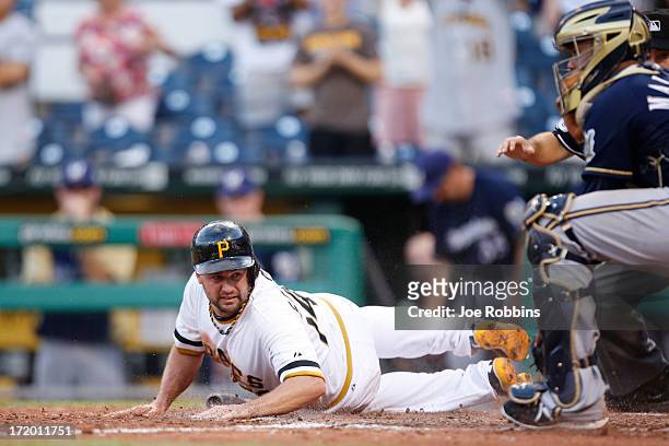 Gaby Sanchez of the Pittsburgh Pirates slides home with the winning run after a single by Russell Martin in the 14th inning of the game against the...