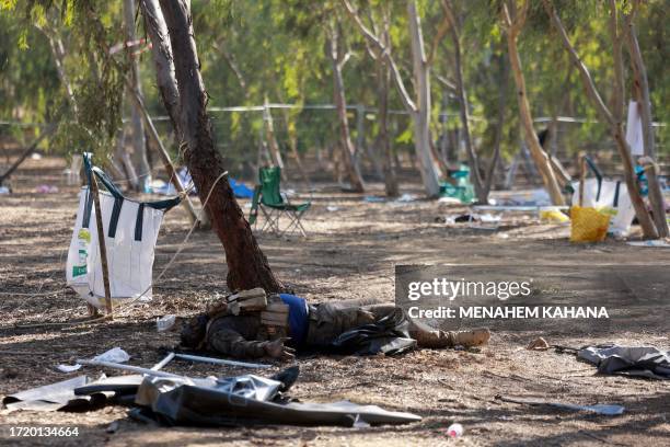 Graphic content / TOPSHOT - The body of a Palestinian gunman remains on the site of the weekend attack by militants on the Supernova Desert Music...