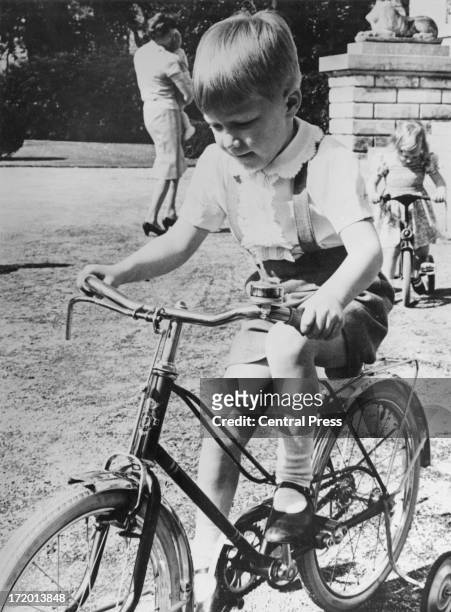 Prince Philippe of Belgium enjoys a ride on his bicycle in the grounds of the Chateau Belvedere on the day before his 5th birthday, 14th April 1965....